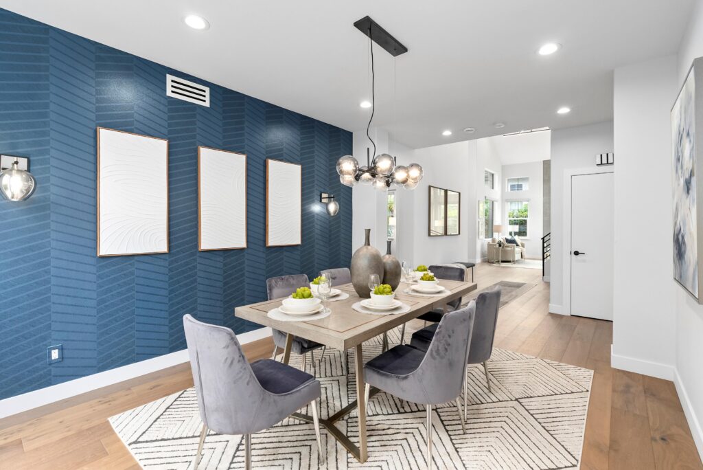 Affordable Home Staging: Maximize Your Home's Value Without Overspending 1 Interior view of a dining room with blue walls and white flooring, showcasing a stylish table and seating arrangement.