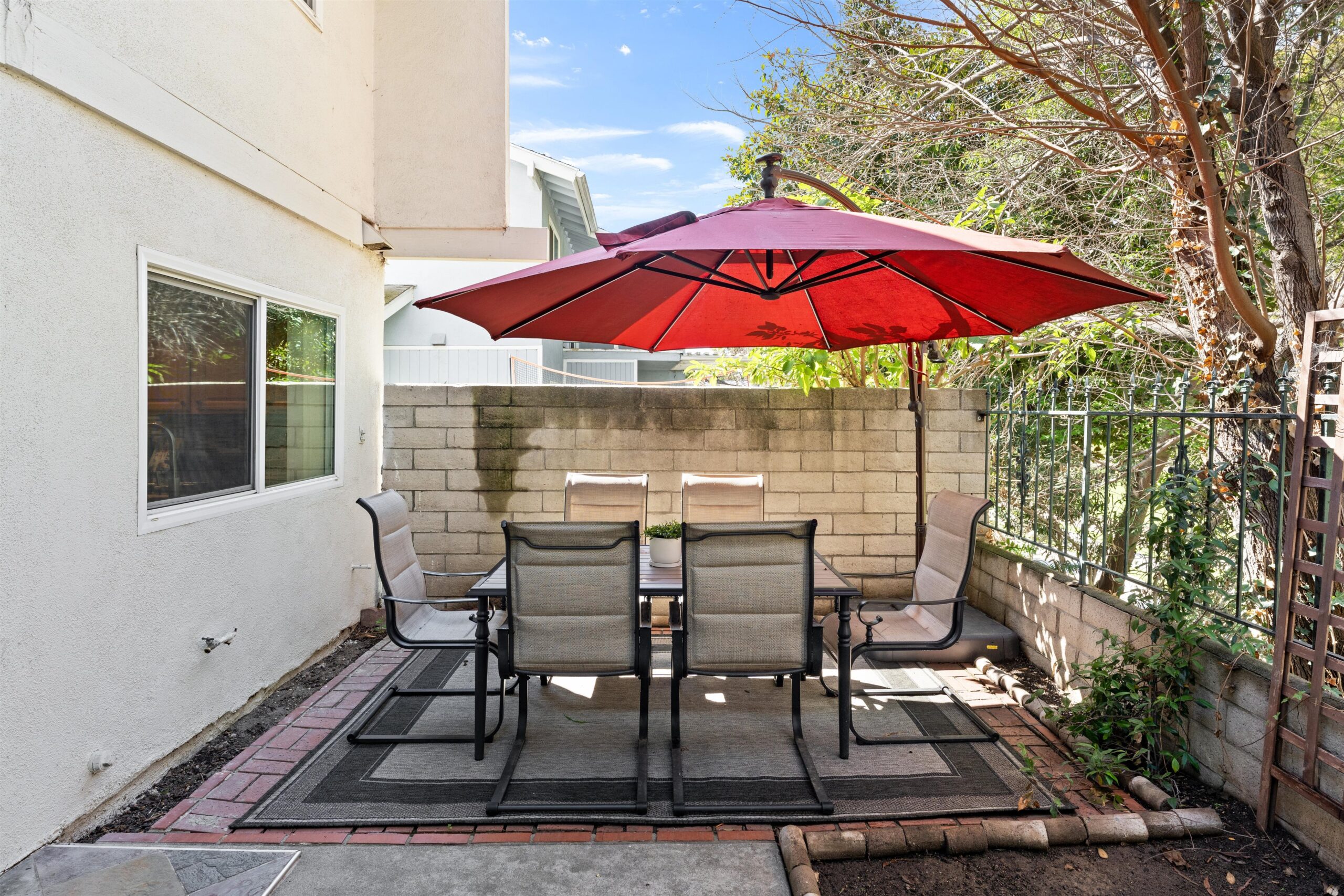Blog 3 A charming patio displaying a table and chairs under an umbrella, perfect for enjoying meals in the fresh air.